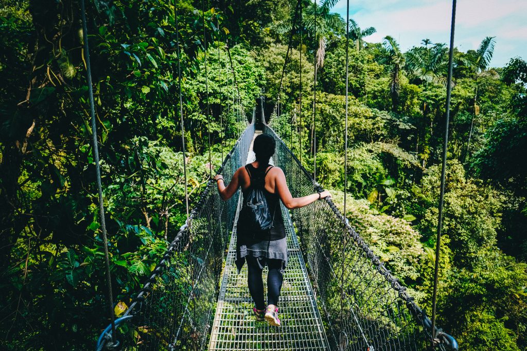 Girl walking across a bridge: pura vida moving to costa rica