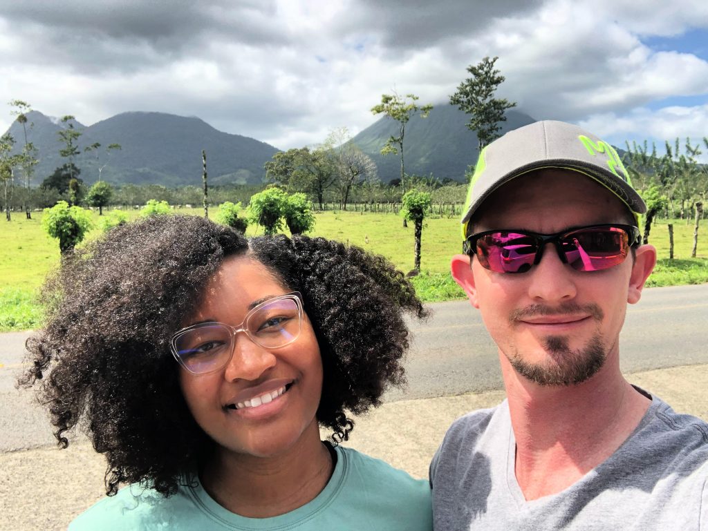 Blogging Income Report: Chris Drown and Jasmine Watts, with Blogging Money Life, at the Arenal volcano in the background. La Fortuna, Costa Rica.