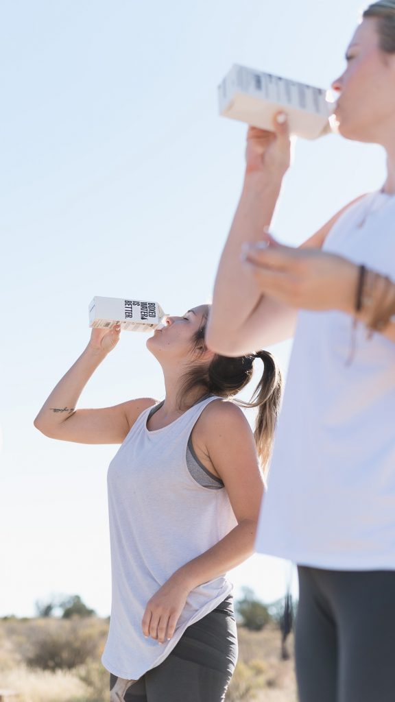 girls drinking water in workout clothes - How To Manifest a Super Fast Metabolism With Lifestyle Changes in 2022